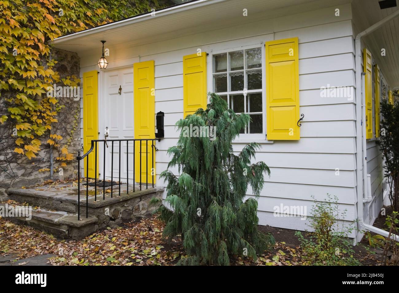 Old circa 1834 fieldstone home with white wood plank cladding and ...