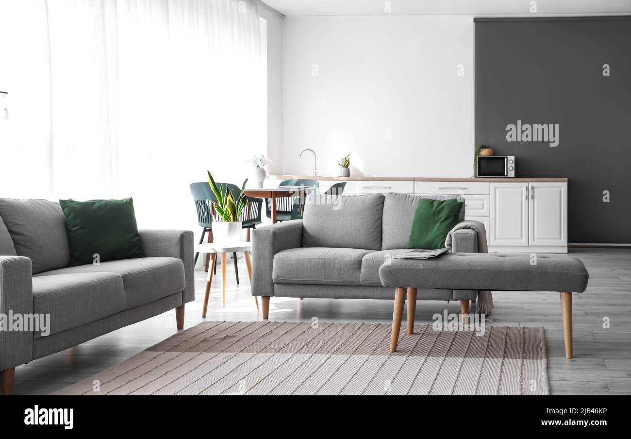 Interior of modern living room with sofas, dining table and bench Stock