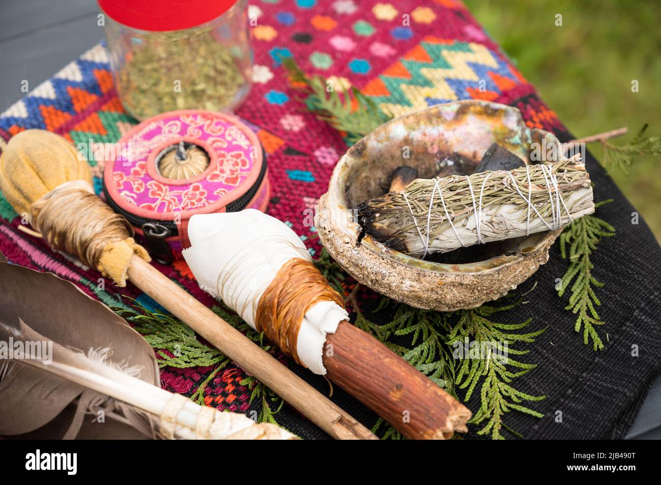 A bundle of sage and an eagle feather are laid out in preparation of a Native American, Indian, or Indigenous smudging ceremony.  Pemberton BC, Canada Stock Photo