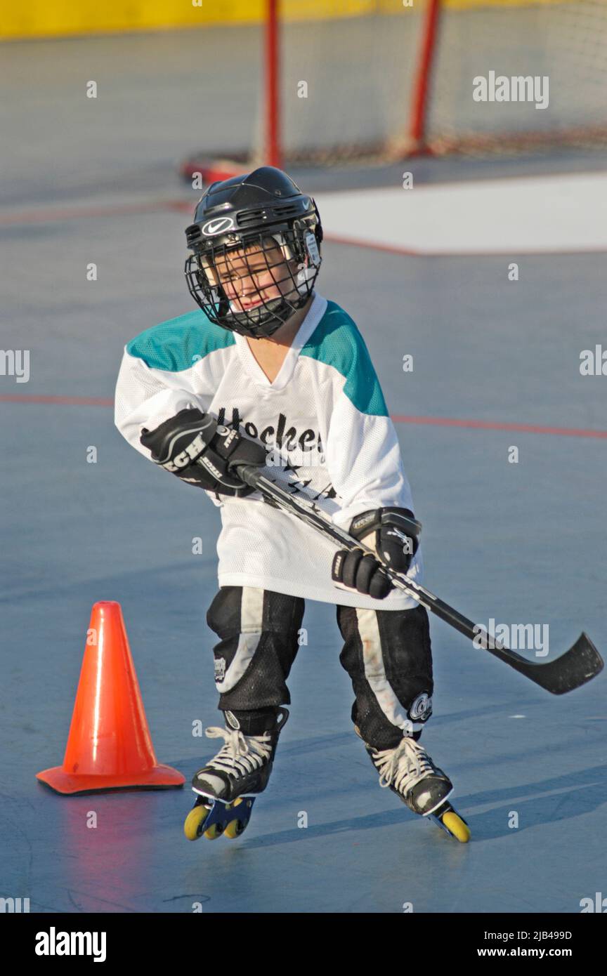 8 Eight year old boy during practice with roller hockey team with full safety gear Stock Photo