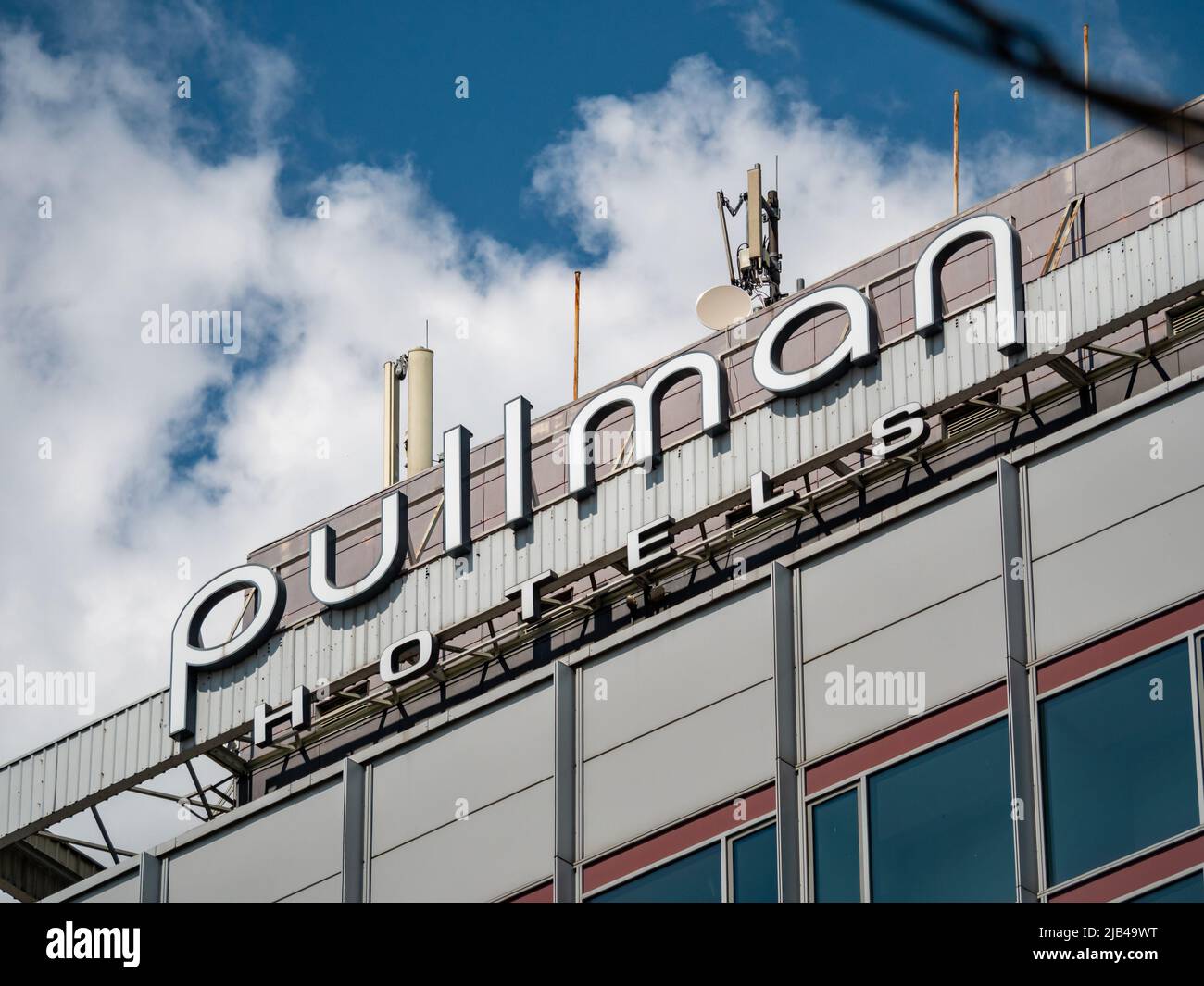 Pullman Hotels lettering on top of a hotel building. Logo of a famous luxury business hotel in the city. A close-up of the brand sign on the wall. Stock Photo