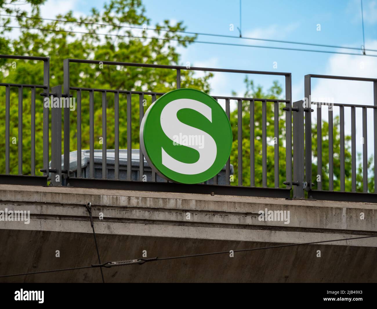 S-Bahn sign on a railing in Germany. This symbol with the letter S is leading to public transportation. The information is showing a station. Stock Photo