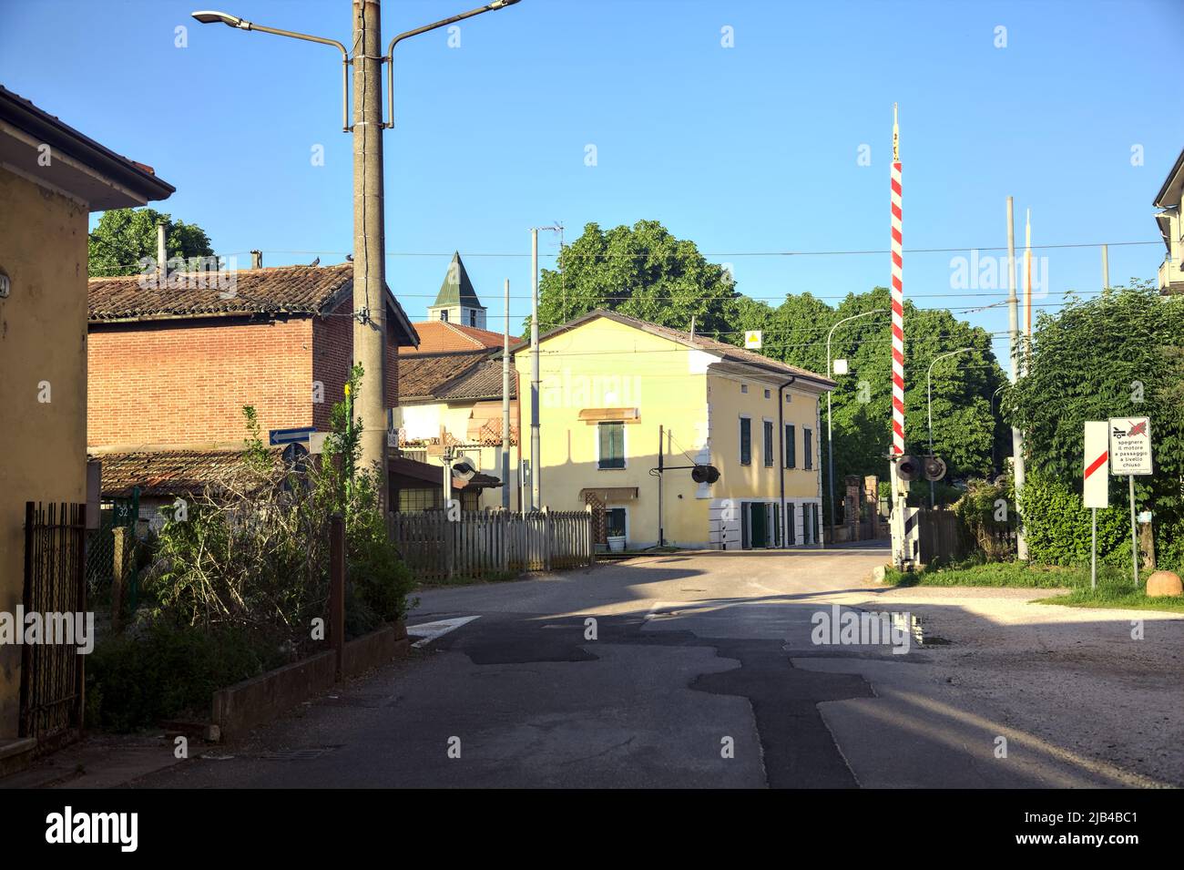 Railroad crossing with lowered bars at sunset Stock Photo Alamy