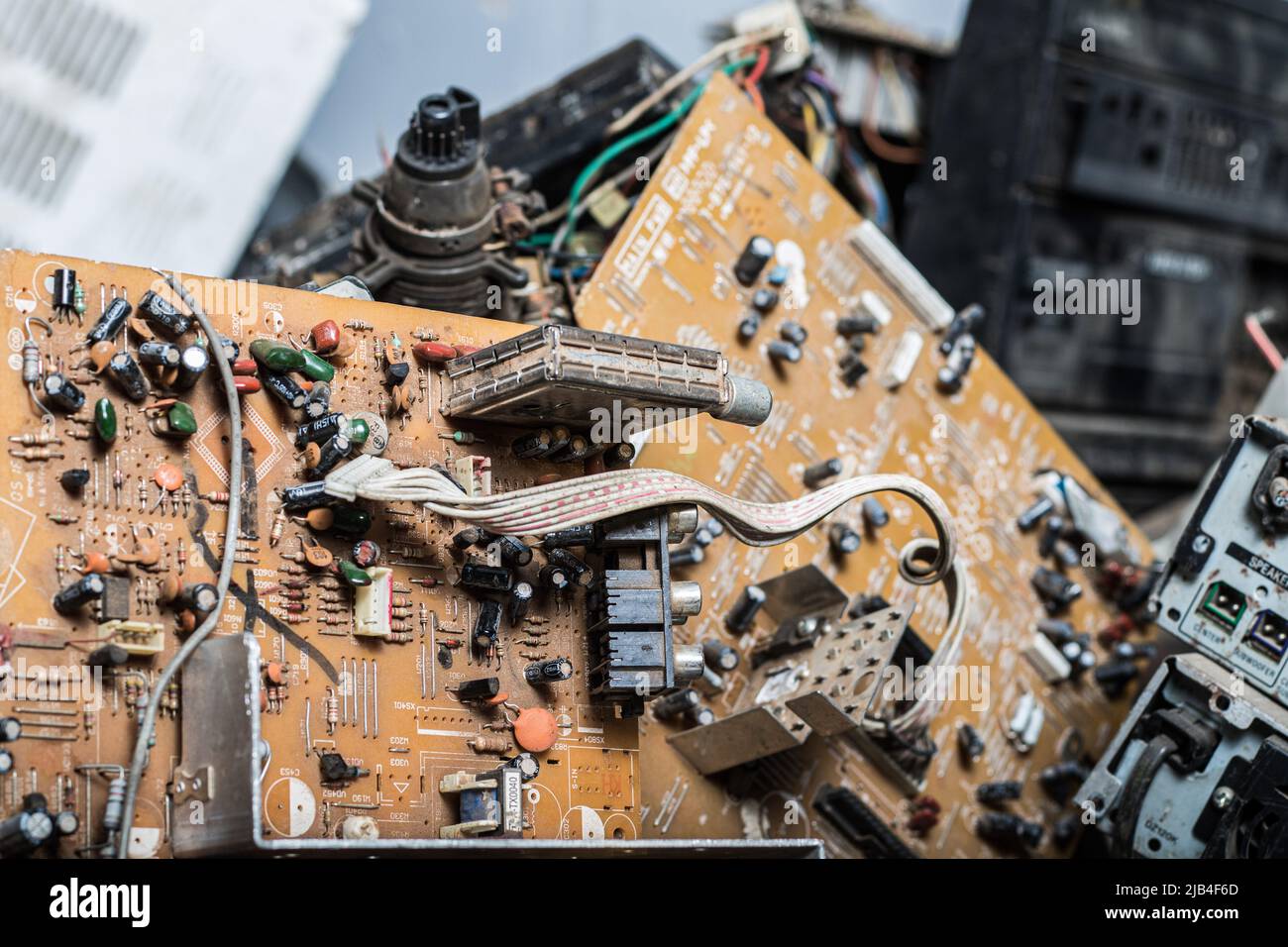 A broken circuit board is seen amidst other electronic wastes at an e
