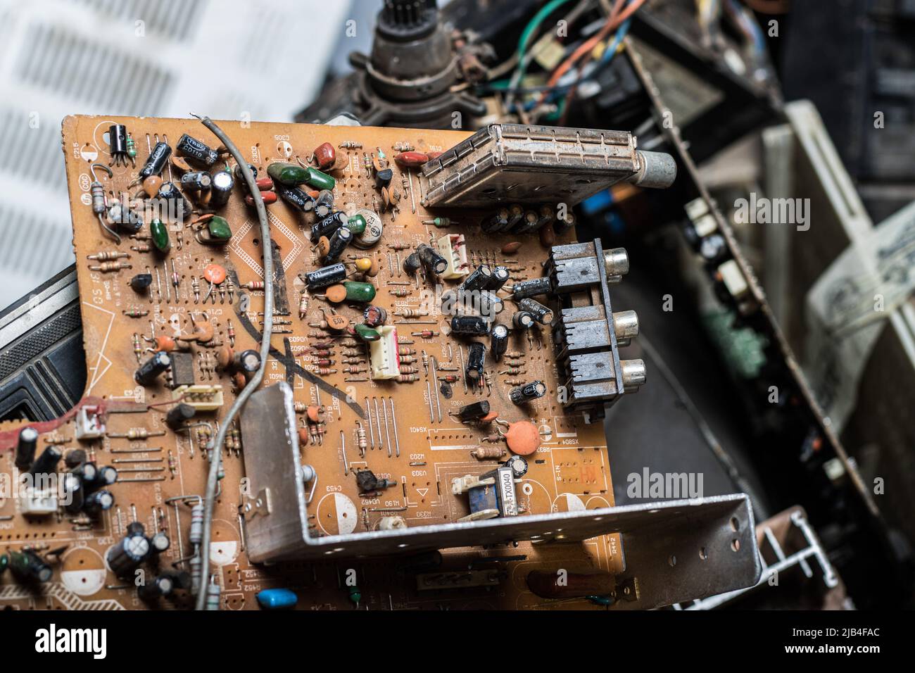 A broken circuit board is seen amidst other electronic wastes at an e