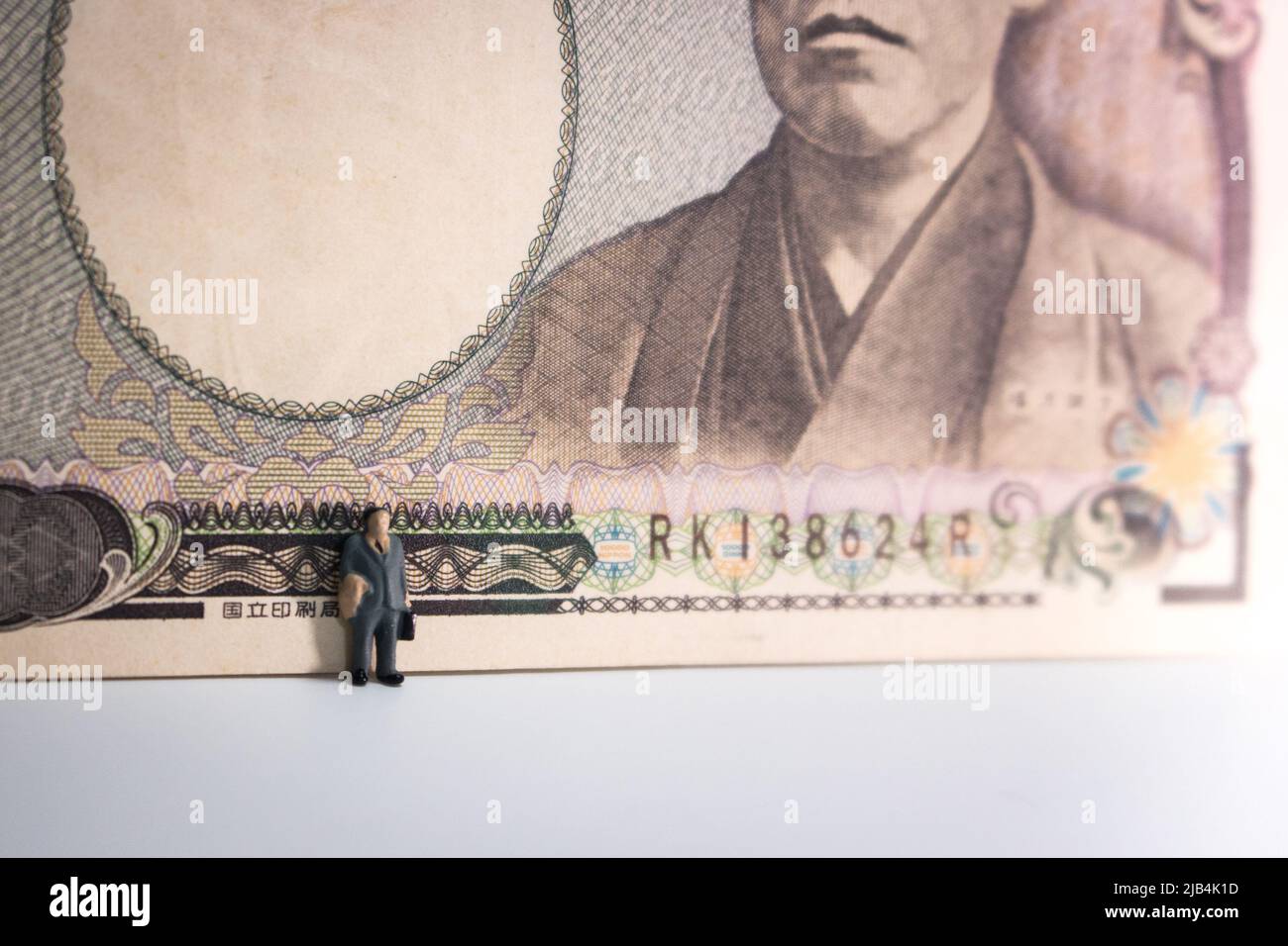 Business man standing on white background with Japanese Yen (10000 Yen
