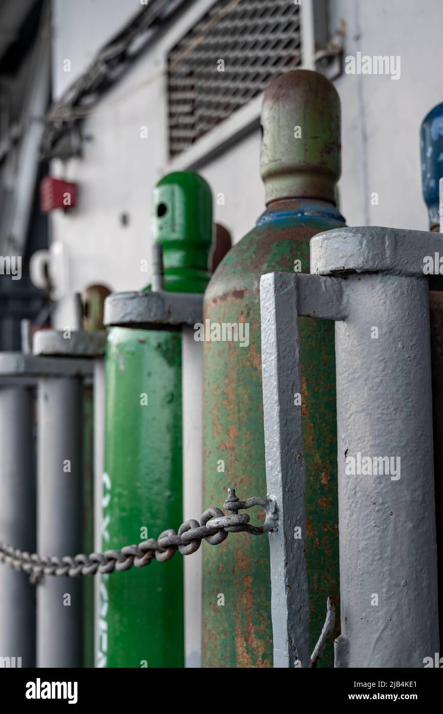 Compressed gas cylinders being stored vertically secured by a metal