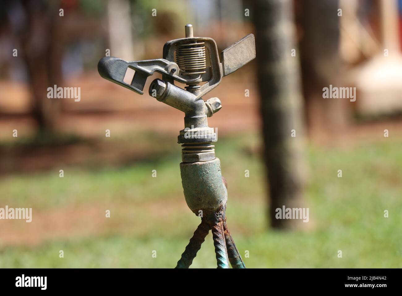 https://c8.alamy.com/comp/2JB4N42/garden-lawn-equipped-with-impact-sprinkler-in-nonworking-condition-on-a-daylight-2JB4N42.jpg