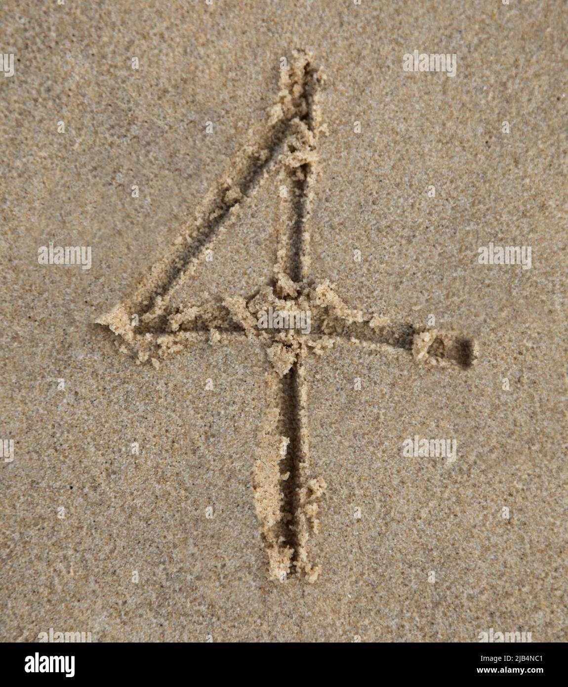 Number Four written in the sand at the beach Stock Photo