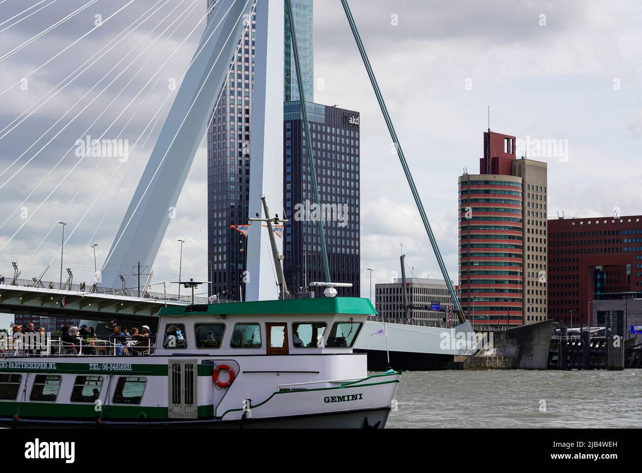 The excursion ship Gemini passes the Erasmus Bridge on the Maas river in Rotterdam, Netherlands on May 26, 2022. Stock Photo