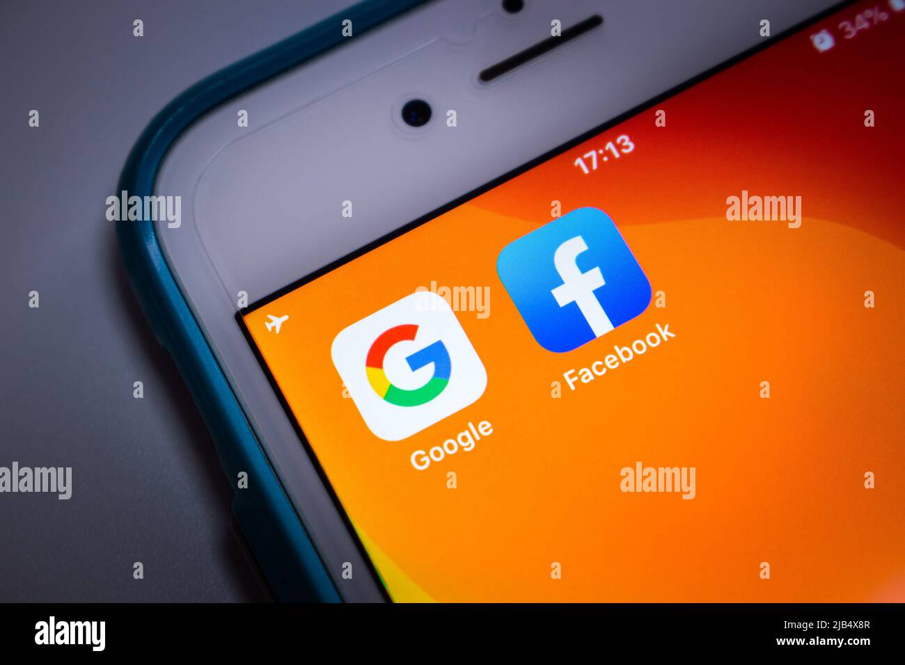 Kumamoto, Japan - May 21 2020 : Google & Facebook icons on orange iPhone screen on white background. Stock Photo