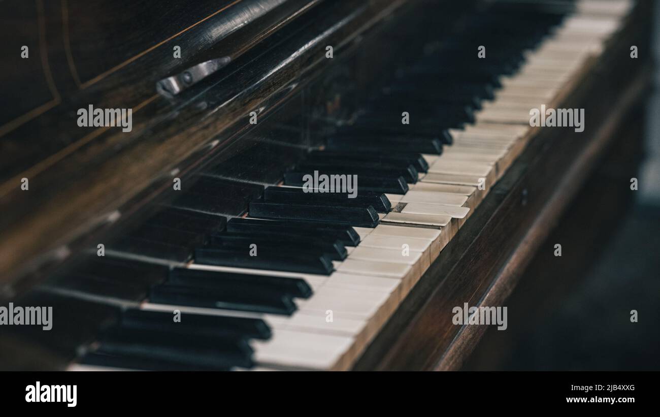 Old piano keys with visible markings or dents and scratches. Used piano