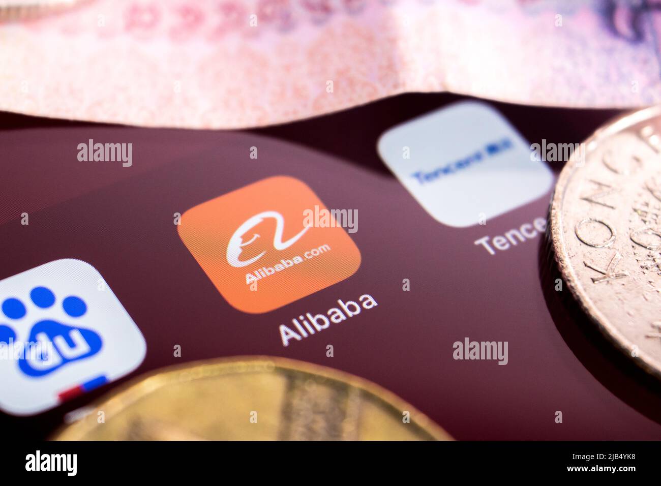 Alibaba logo, founded on 4 April 1999 in Hangzhou, Zhejiang, with Chinese big tech company logos (Baidu, Tencent and Huawei) & money on an iPhone. Stock Photo