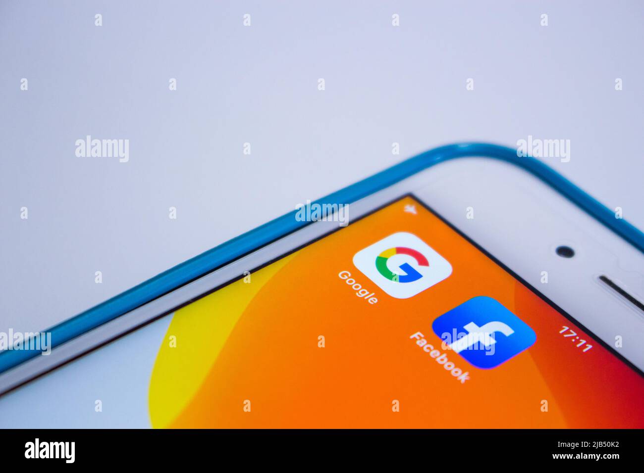 Kumamoto, Japan - May 21 2020 : Google & Facebook icons on orange iPhone screen on white background. Stock Photo