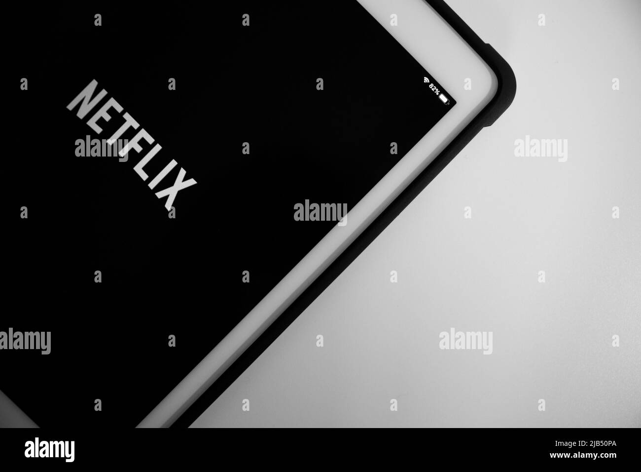 Kumamoto, Japan - May 7 2020 : Netflix logo on iPad in monochrome. Netflix, Inc. is an US media-services provider & production company based in CA Stock Photo
