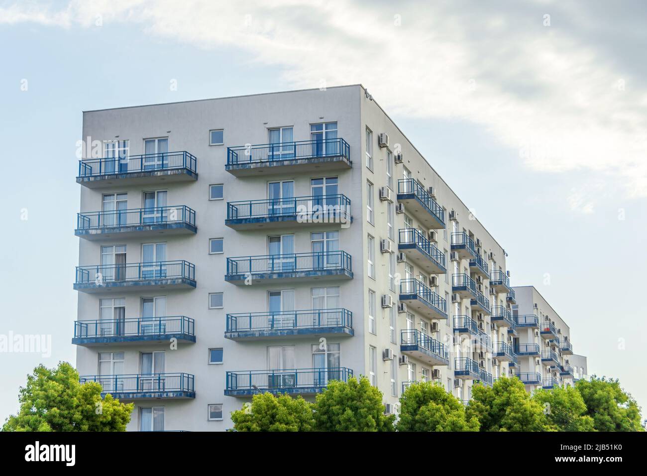 Multi-storey residential buildings in an ecologically clean area for the population, with green trees Stock Photo