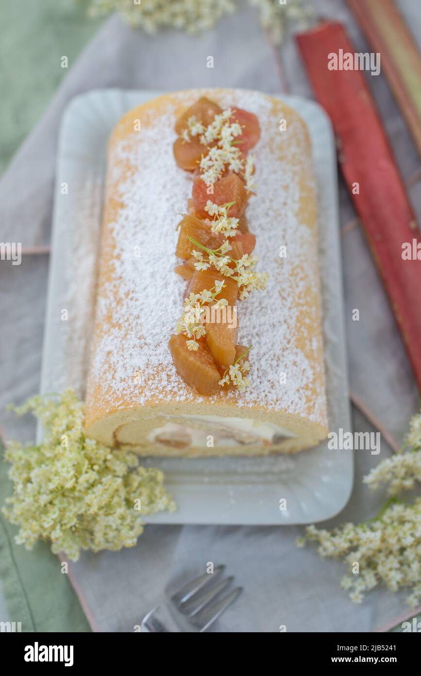 Sweet home made bisuit roll with rhubarb and elderflower on a table Stock Photo