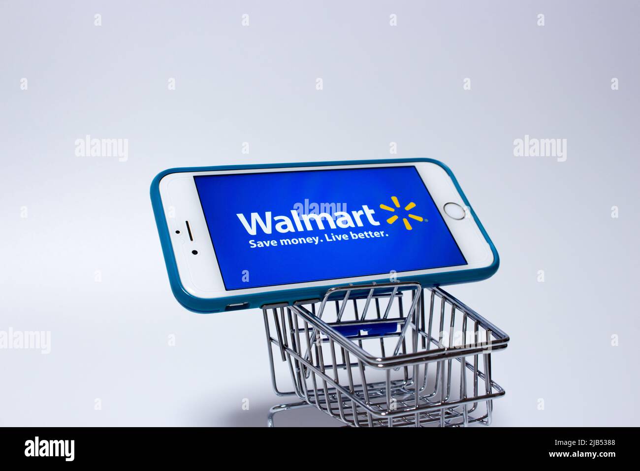 Walmart Logo on iPhone in a shopping cart. Walmart Inc. is an US retail corporation that operates a chain of hypermarkets, discount & grocery stores Stock Photo