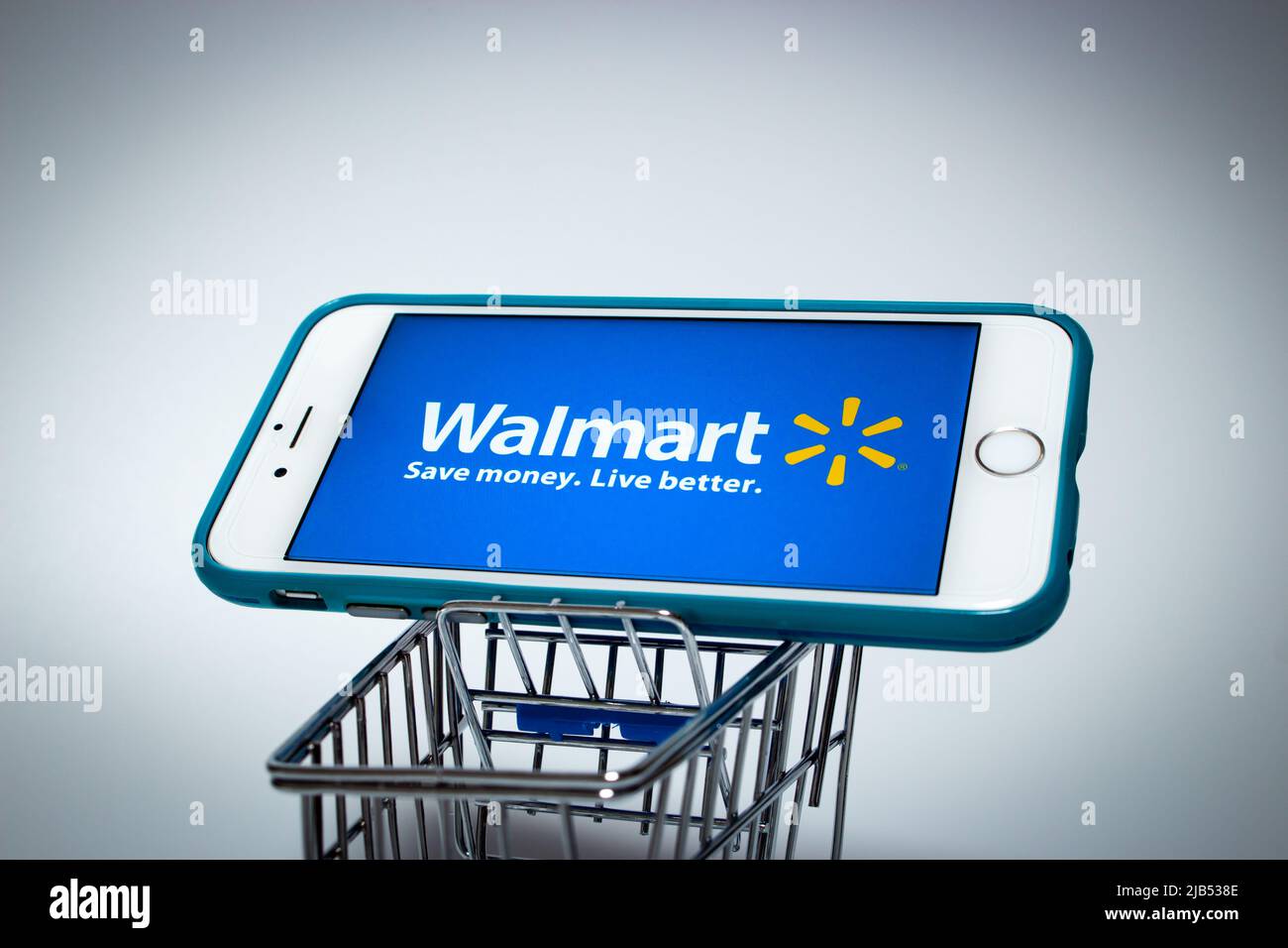 Walmart Logo on iPhone in a shopping cart. Walmart Inc. is an US retail corporation that operates a chain of hypermarkets, discount & grocery stores Stock Photo