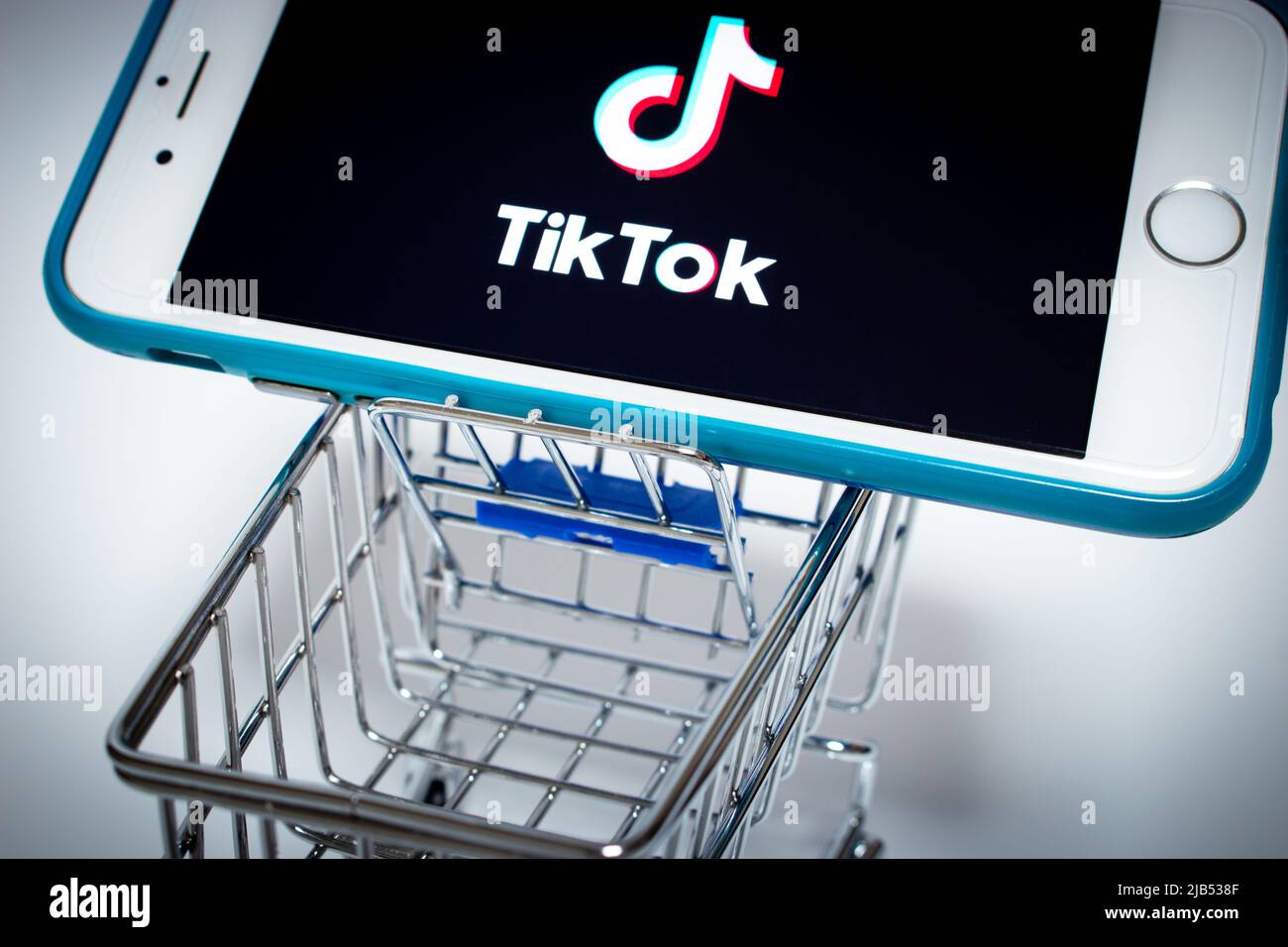 TikTok Logo on iPhone in miniaturae shopping cart. TikTok is a Chinese