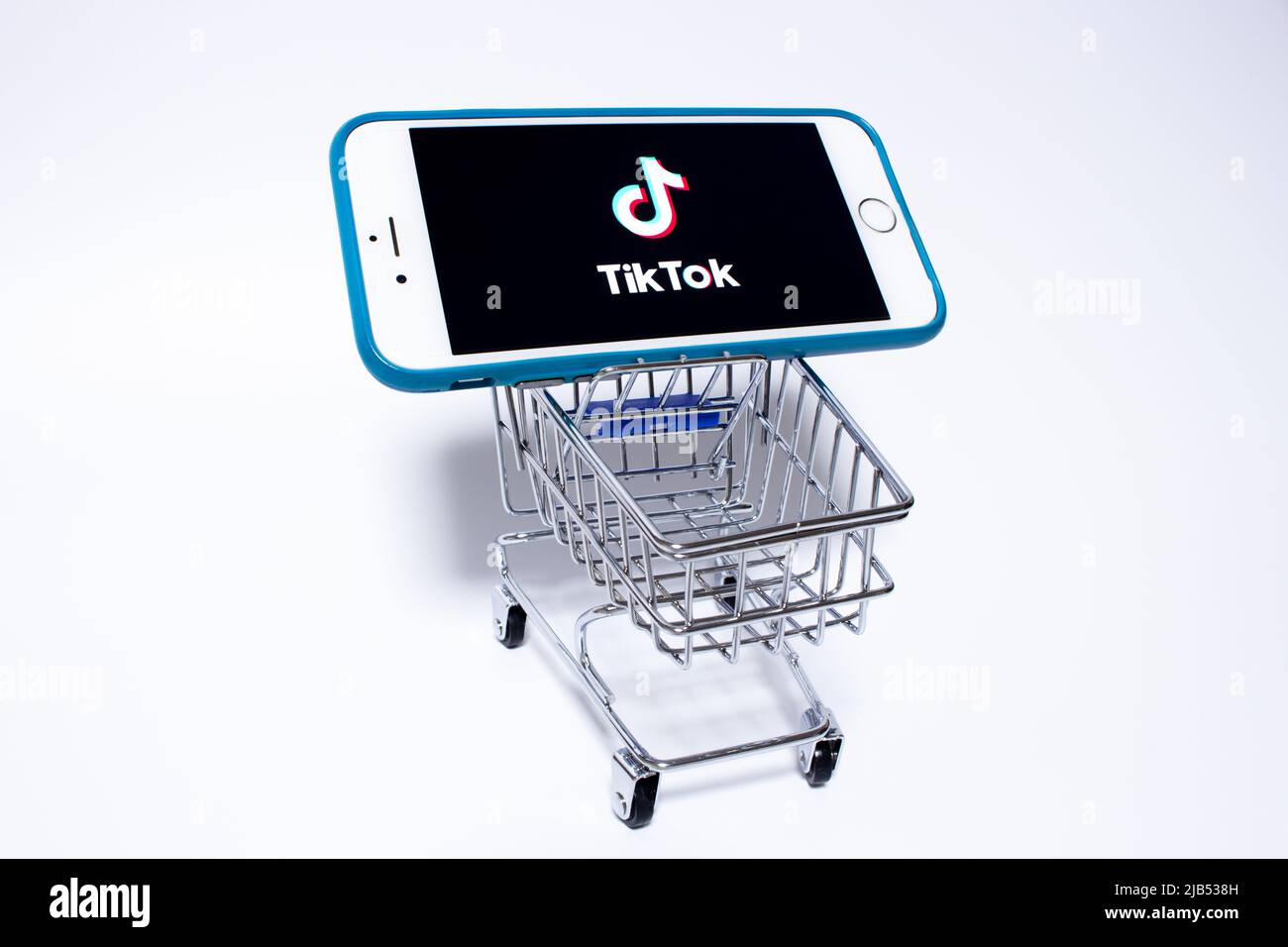 TikTok Logo on iPhone in miniaturae shopping cart. TikTok is a Chinese