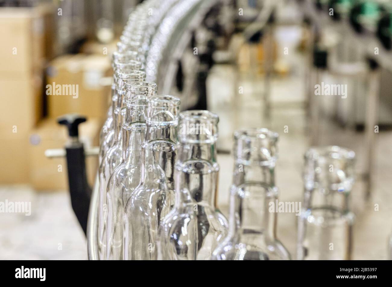 Production line transports empty glass bottles for alcohol Stock Photo