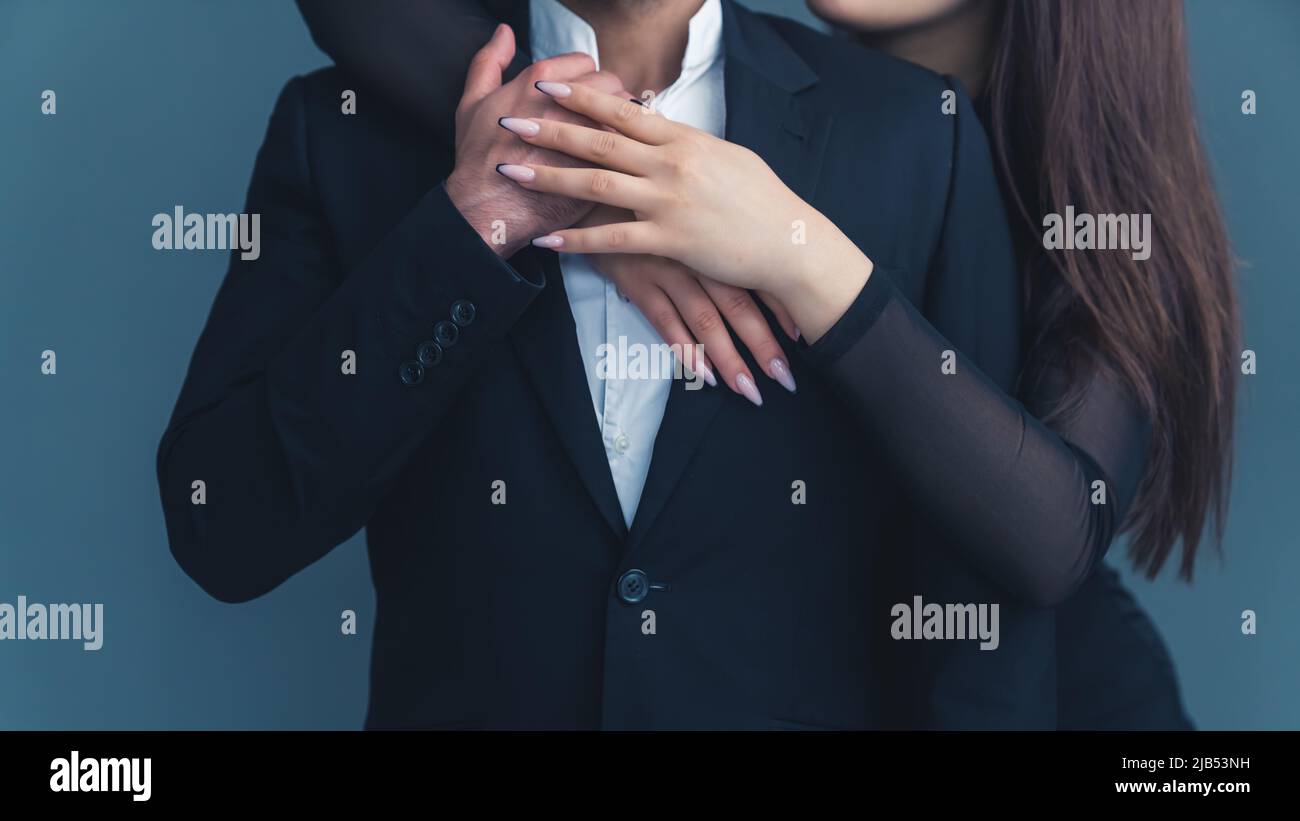 Closeup studio shot of hands of a caucasian woman with beautiful long nails  and beautiful manicure holding hugging a man in a black elegant suit. High  quality photo Stock Photo - Alamy
