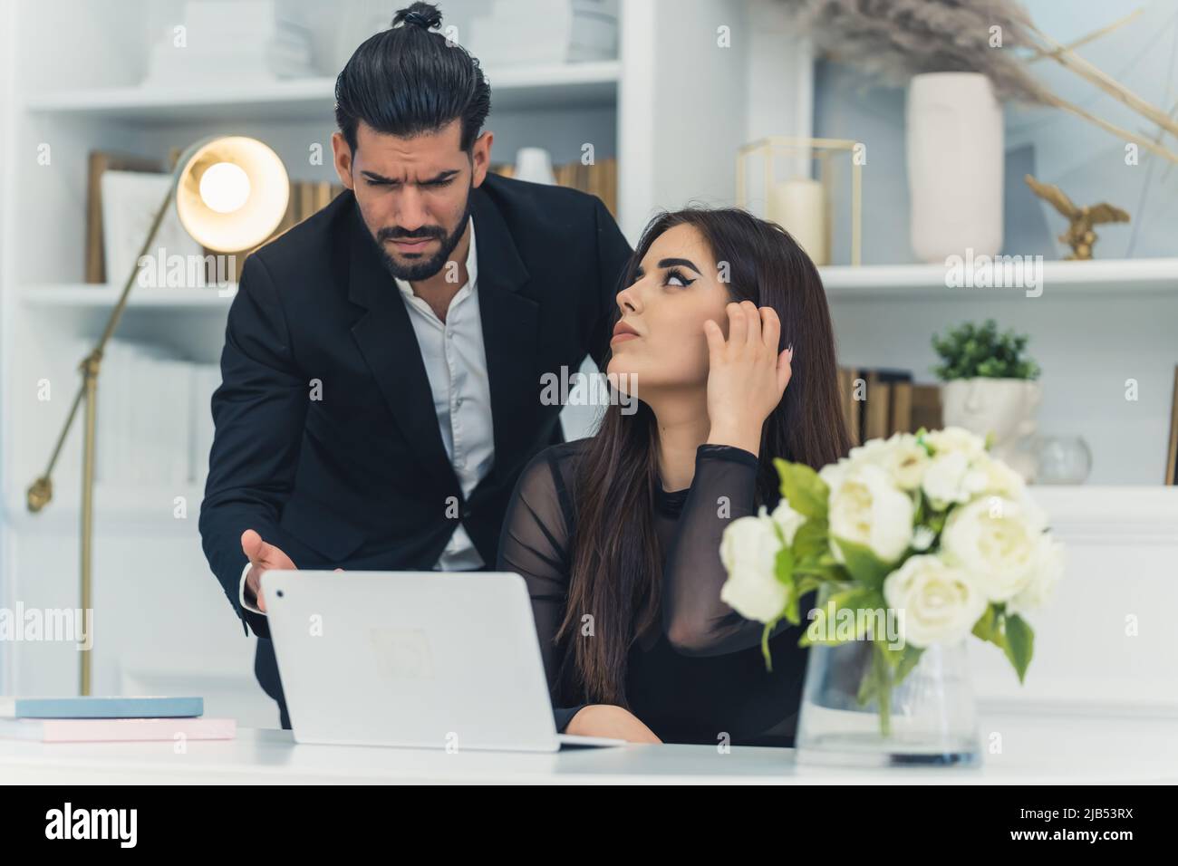 Mad bearded middle-aged boss yells at his female worker. Not helpful male boss devastated after seeing sales results. Office interior. High quality photo Stock Photo