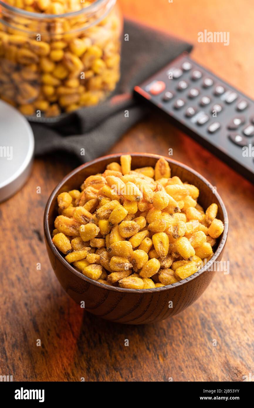 Roasted salted corn snack in bowl on a wooden table. Stock Photo