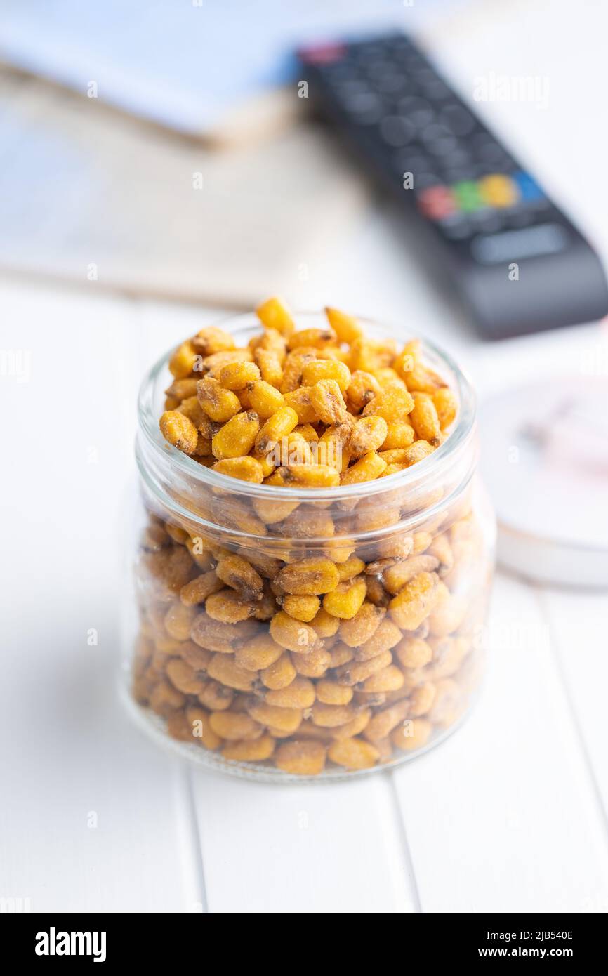Roasted salted corn snack in jar on a white table. Stock Photo
