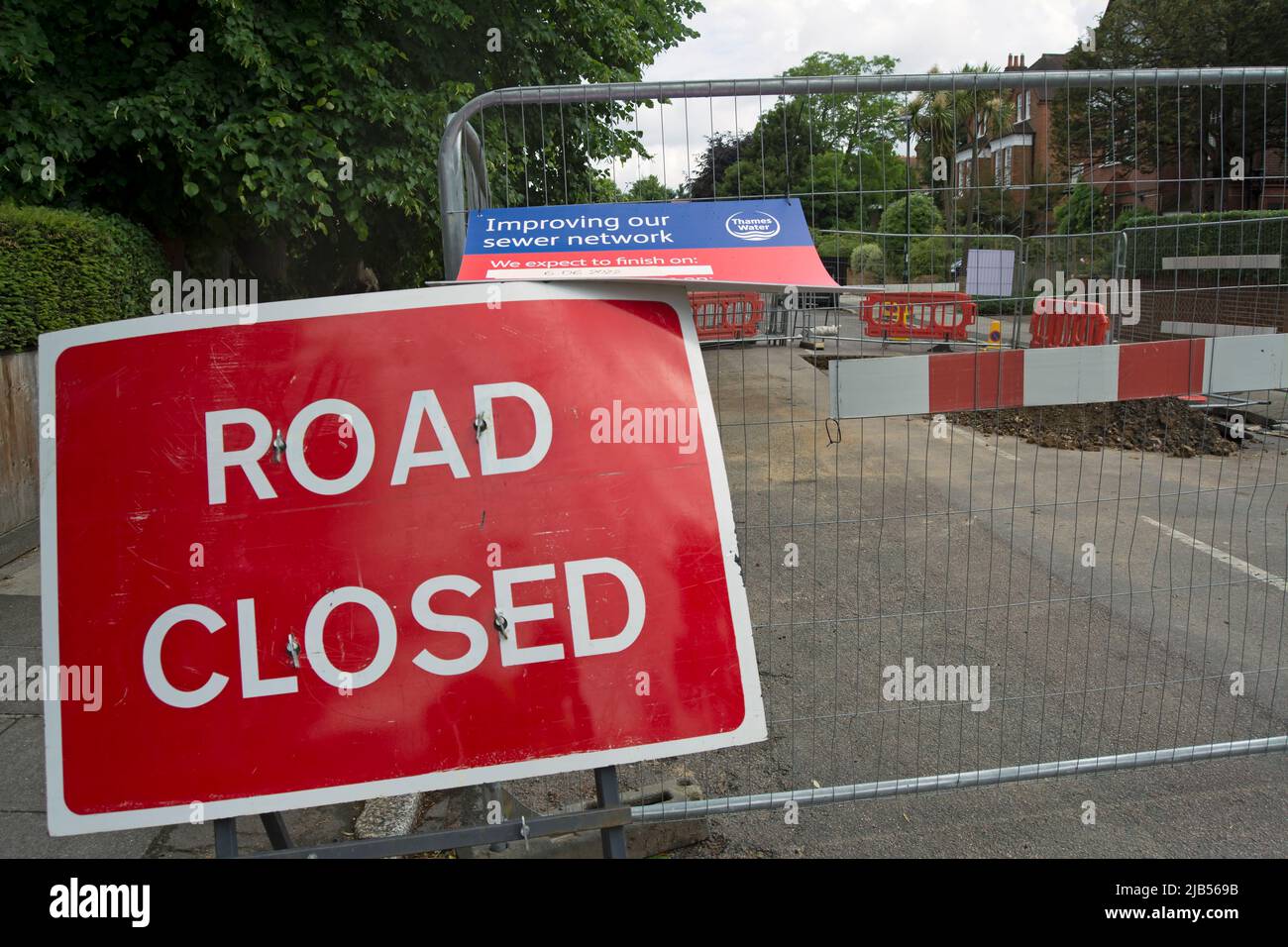 road closed sign adjacent to works fenced off by thames water to carry out work on sewer pipes in strawberry hill, middlesex, england Stock Photo