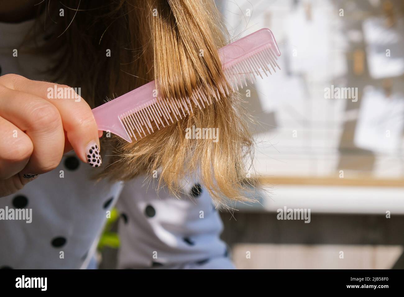 Worried woman holding brush with hair loss after brushing. Clump of