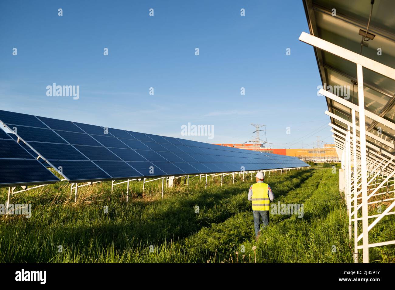 Worker in solar farm. Solar photovoltaic panels. Solar energy. Eco