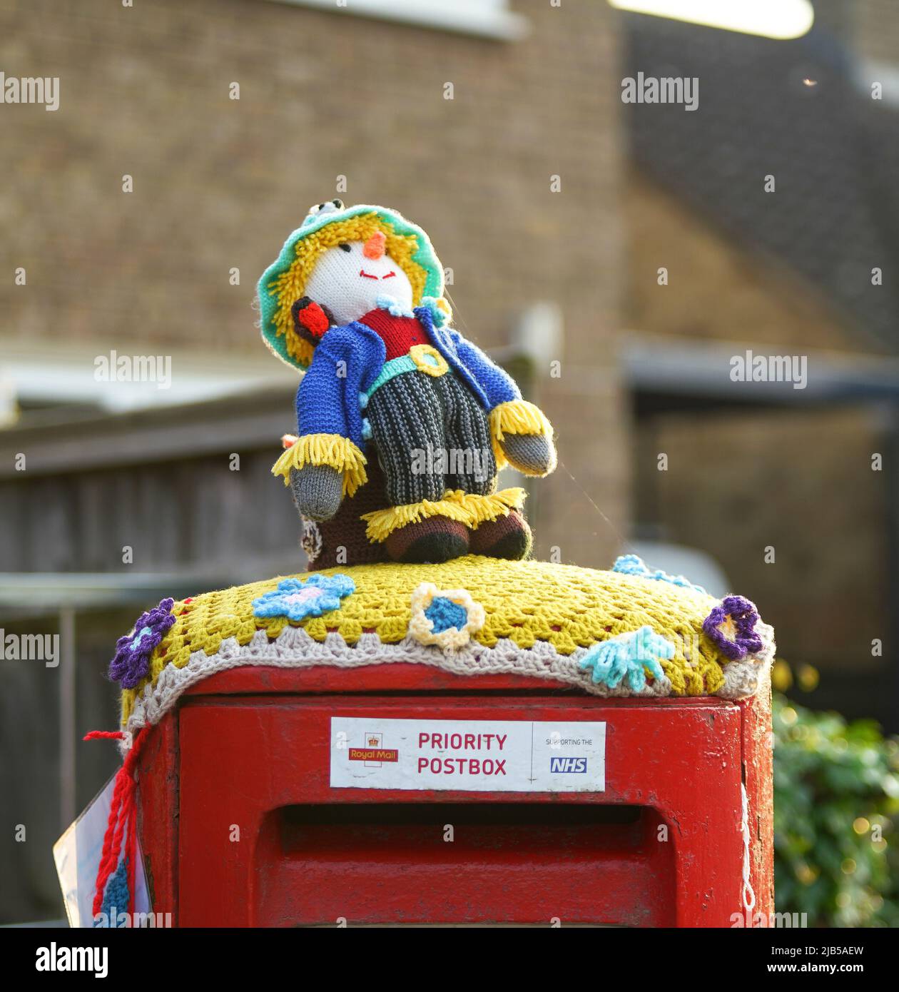A crocheted Worzel Gummidge stands on top of a post box in Launton village, near Bicester, Oxfordshire Stock Photo