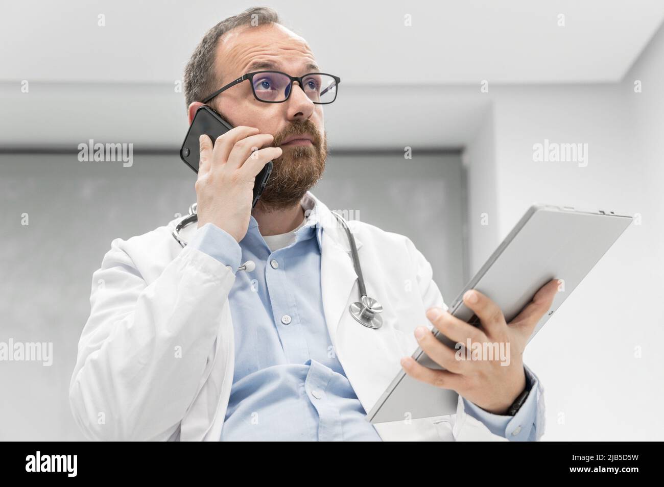Doctor in office talking on phone. High quality photography. Stock Photo