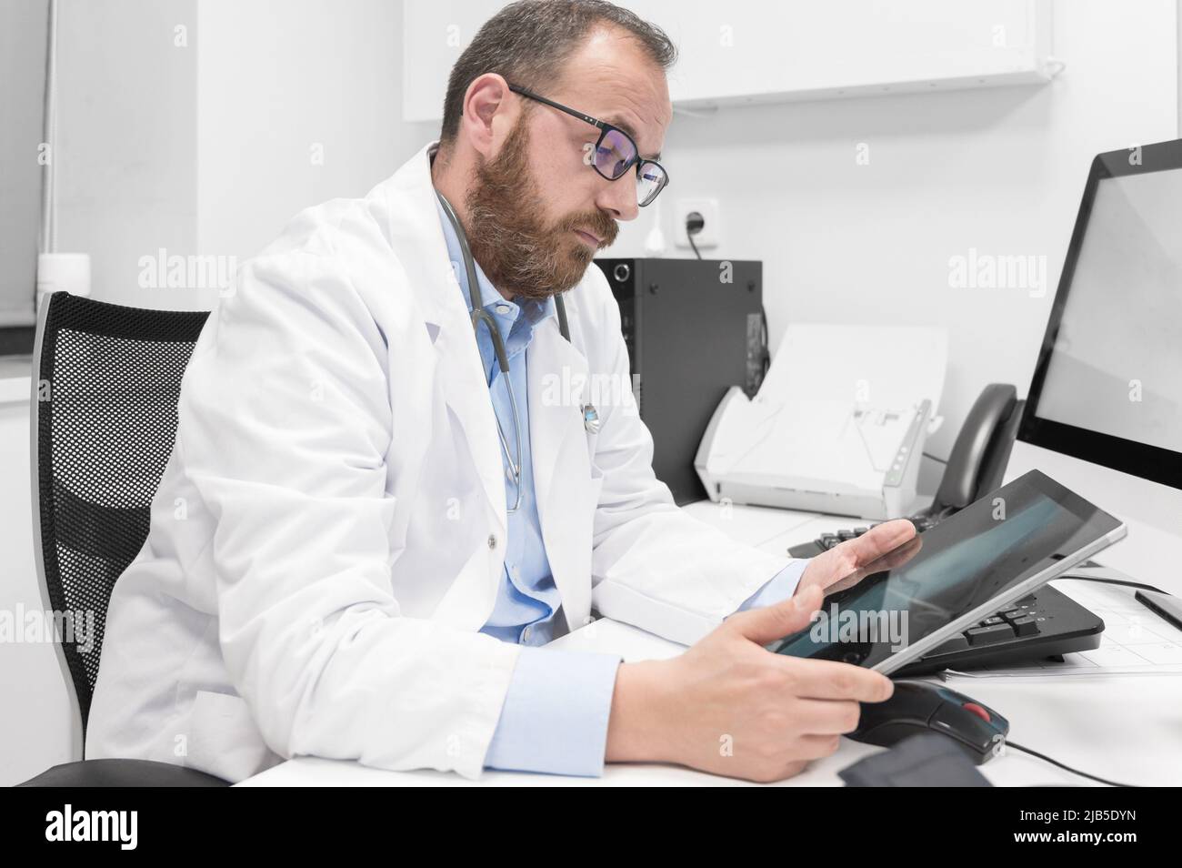 Doctor using his tablet computer at work. High quality photo. Stock Photo