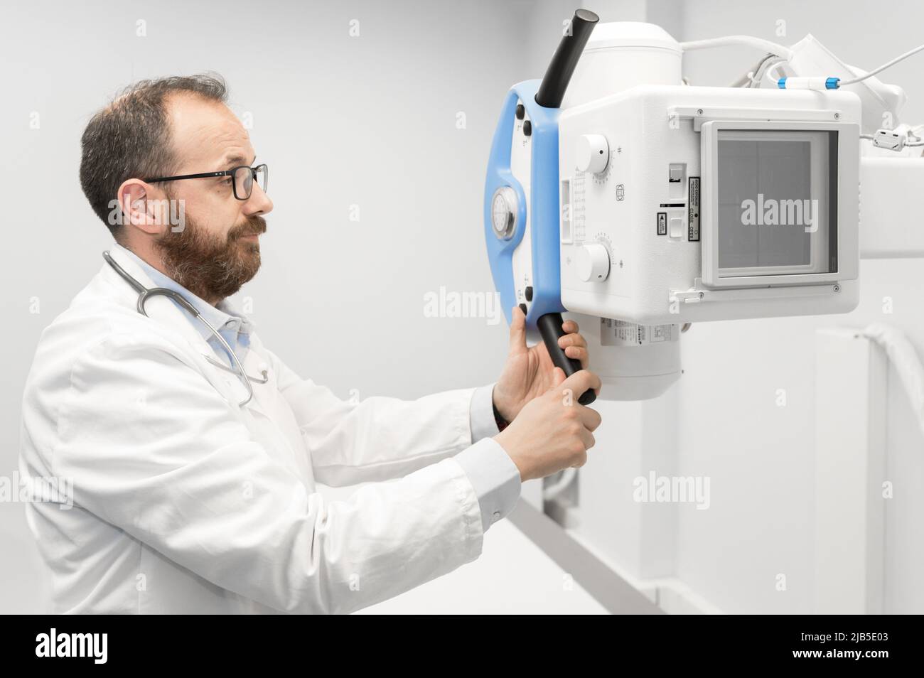 Doctor operating X-ray machine in radiology department. High quality photography. Stock Photo