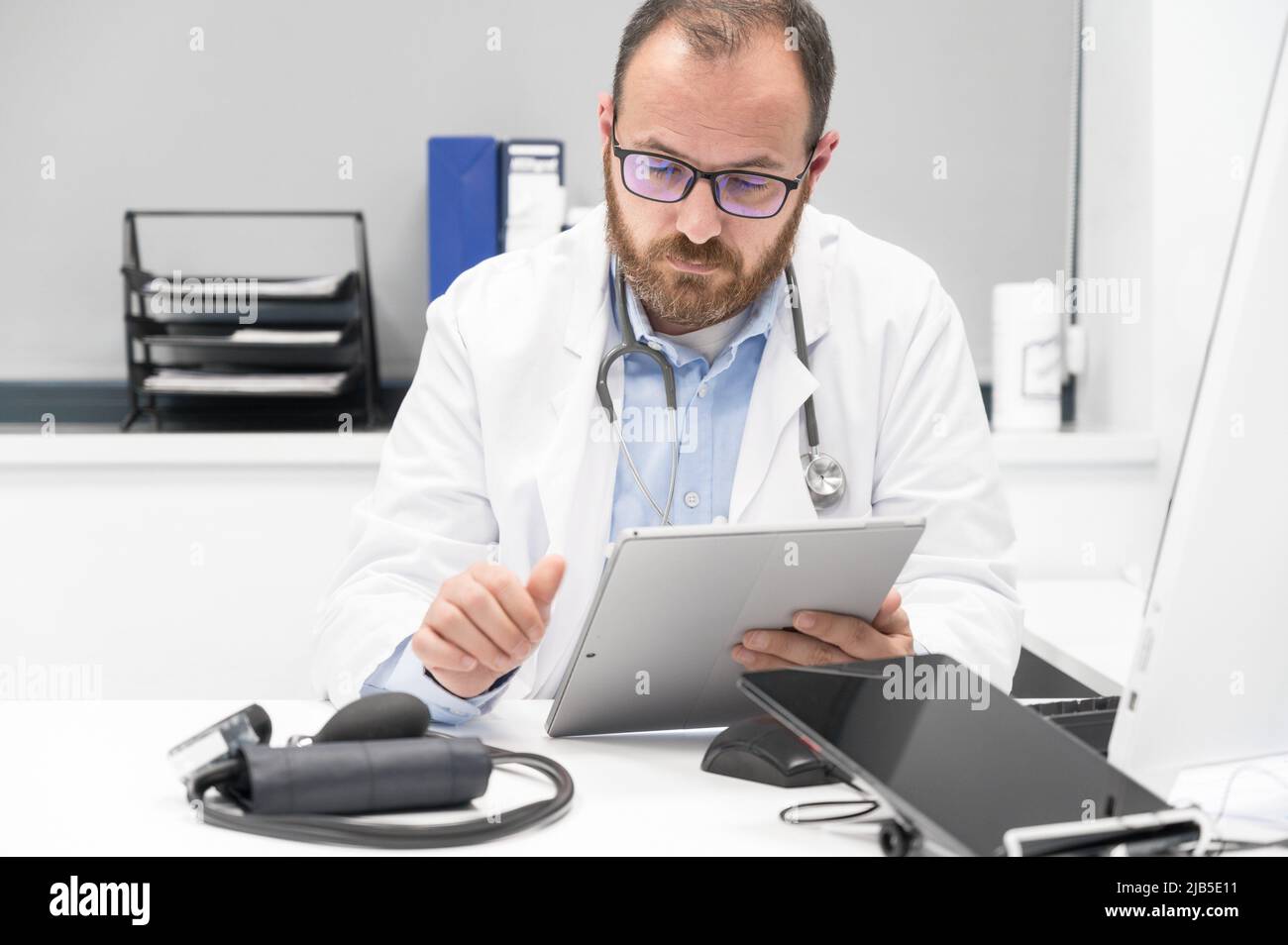 Doctor using his tablet computer at work. High quality photo. Stock Photo