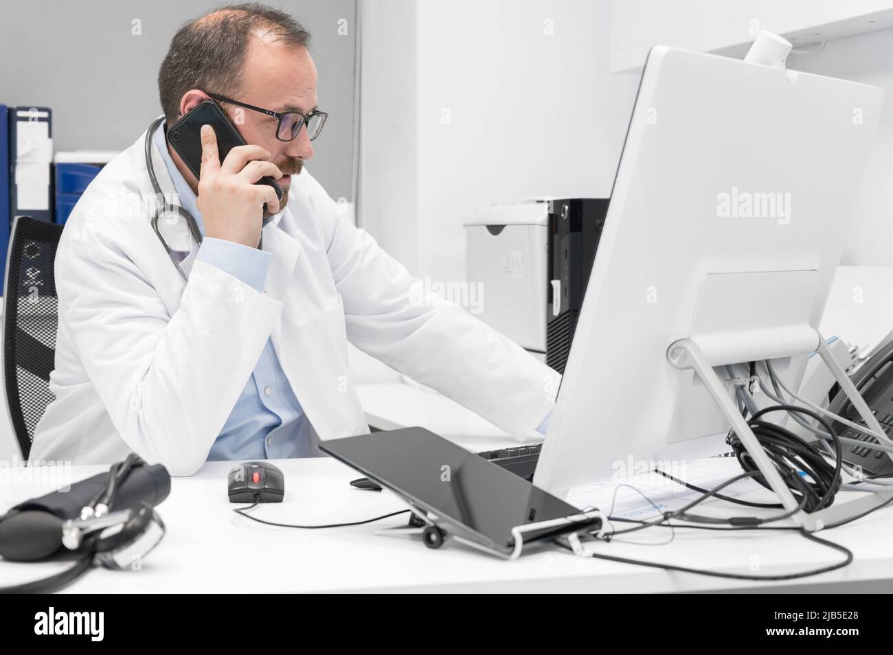 Doctor in office talking on phone. High quality photography. Stock Photo