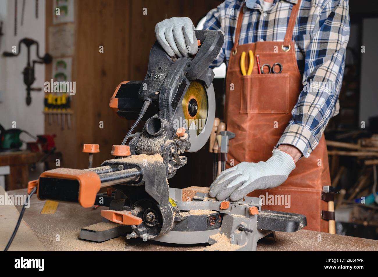 Carpenter using an electric circular saw, cutting piece of wood. High quality photo. Stock Photo