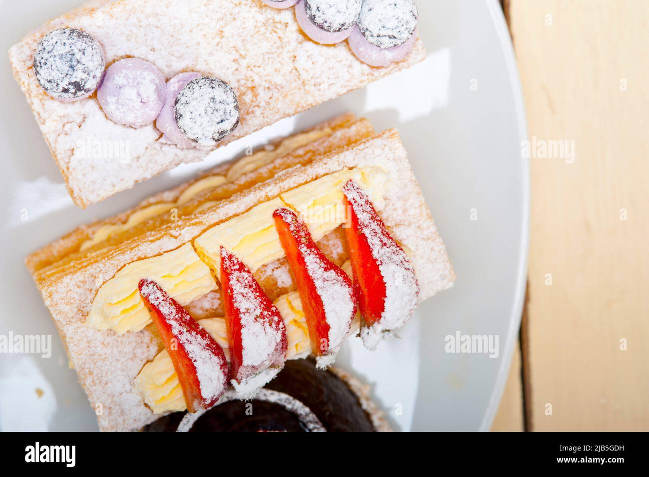 selection of fresh cream napoleon and chocolate mousse cake dessert plate. Stock Photo