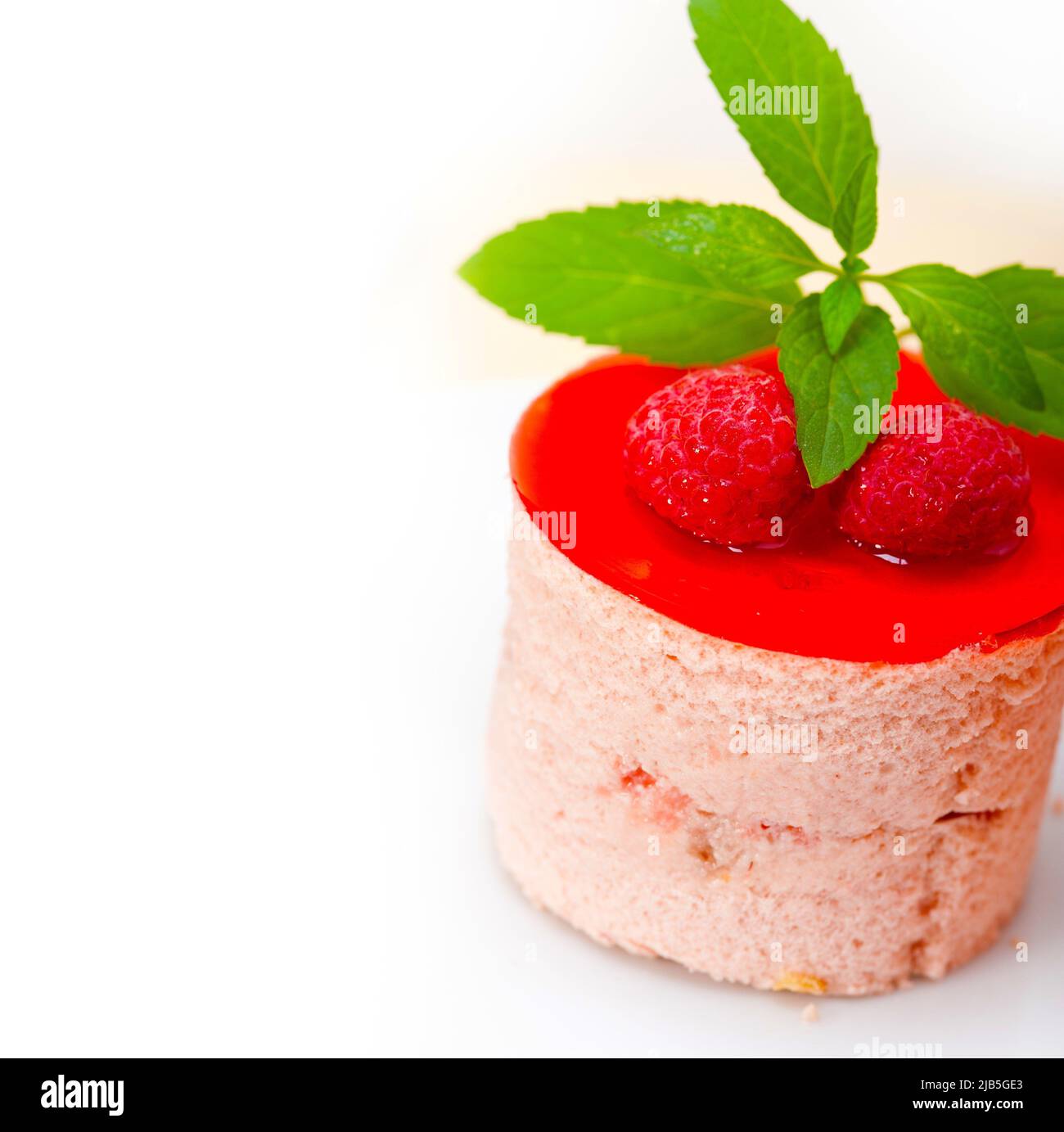 fresh raspberry cake mousse dessert round shape with mint leaves. Stock Photo