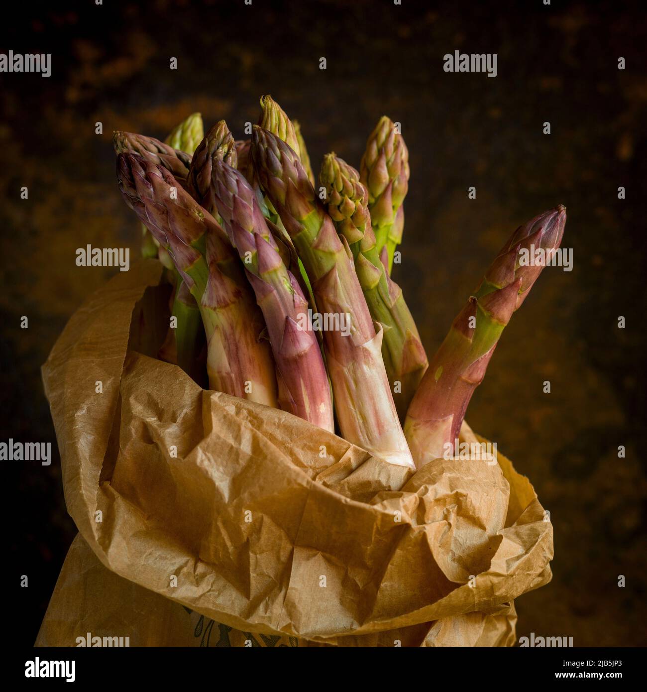 Bunch of fresh asparagus on brown background Stock Photo