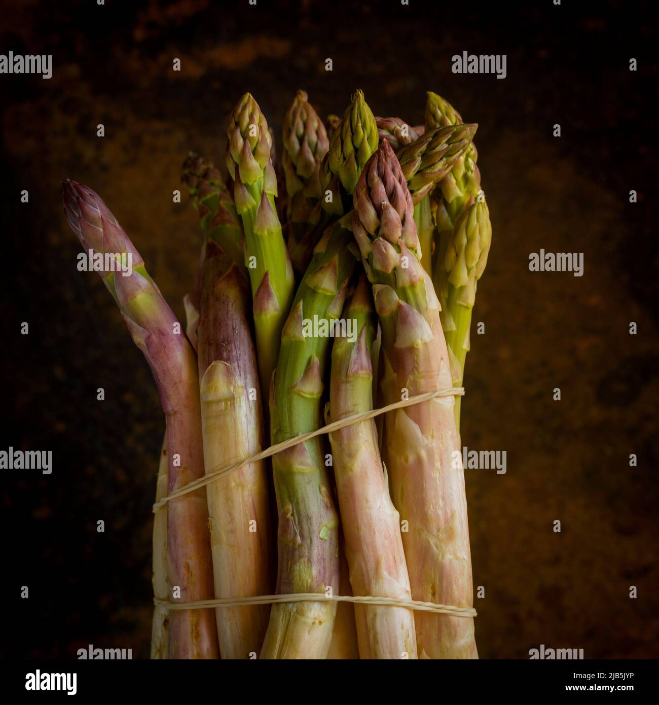 Bunch of fresh asparagus on brown background Stock Photo