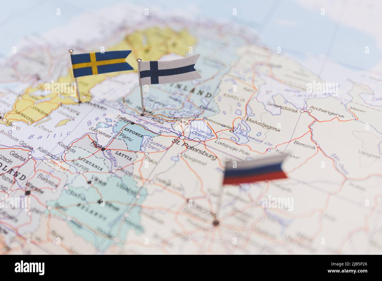 Finland and Sweden and Russian flags on Europe map. NATO flag in background Stock Photo