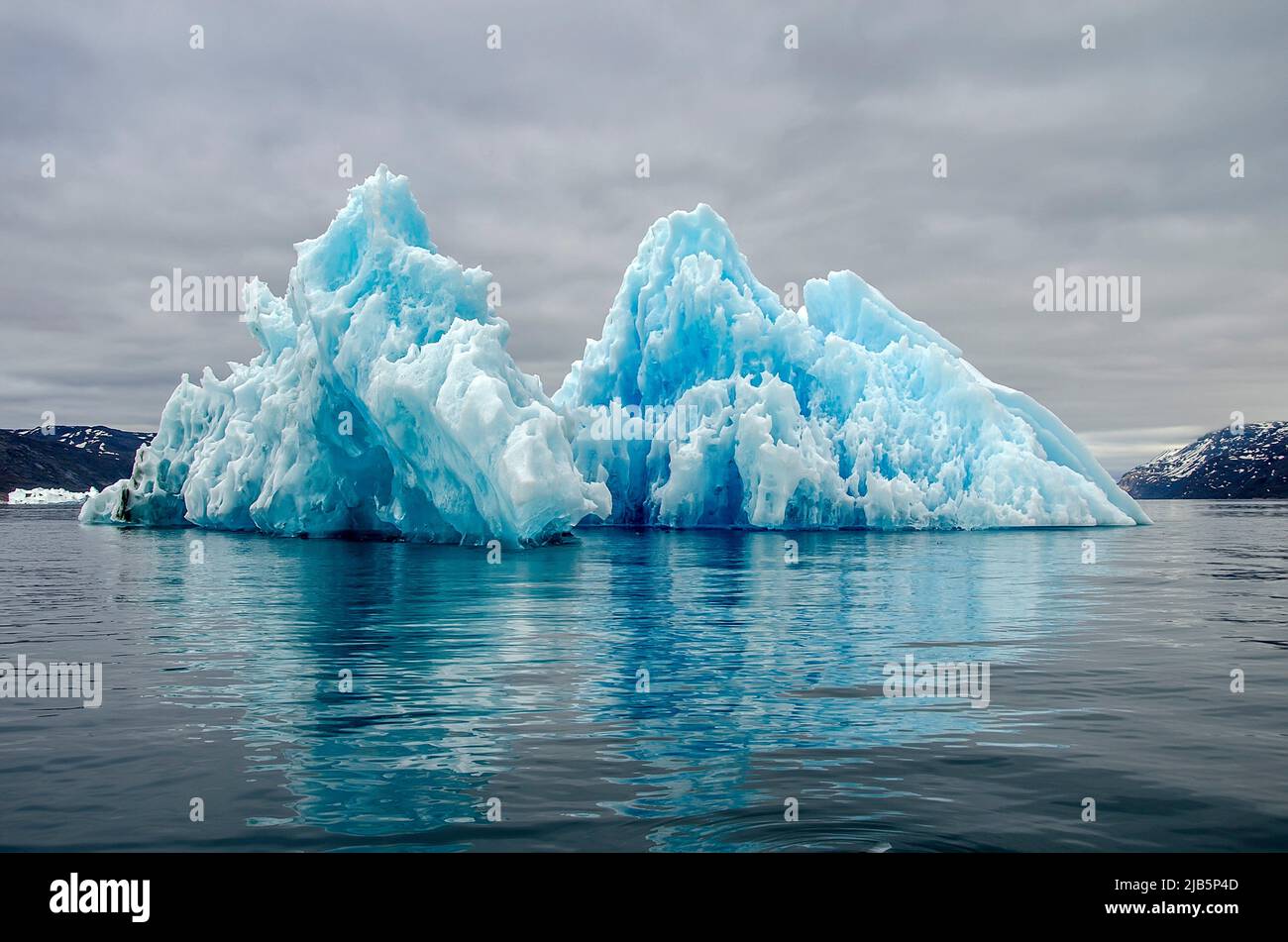 Bluish iceberg melting and forming curious shapes. Stock Photo