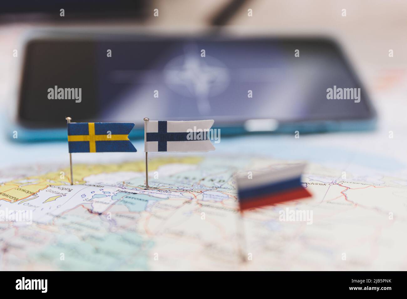 Finland and Sweden and Russian flags on Europe map. NATO flag in background Stock Photo