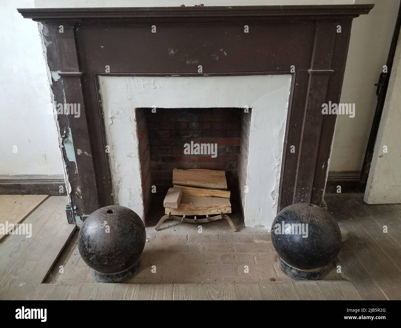 old fireplace with wood and two black cannon balls Stock Photo Alamy