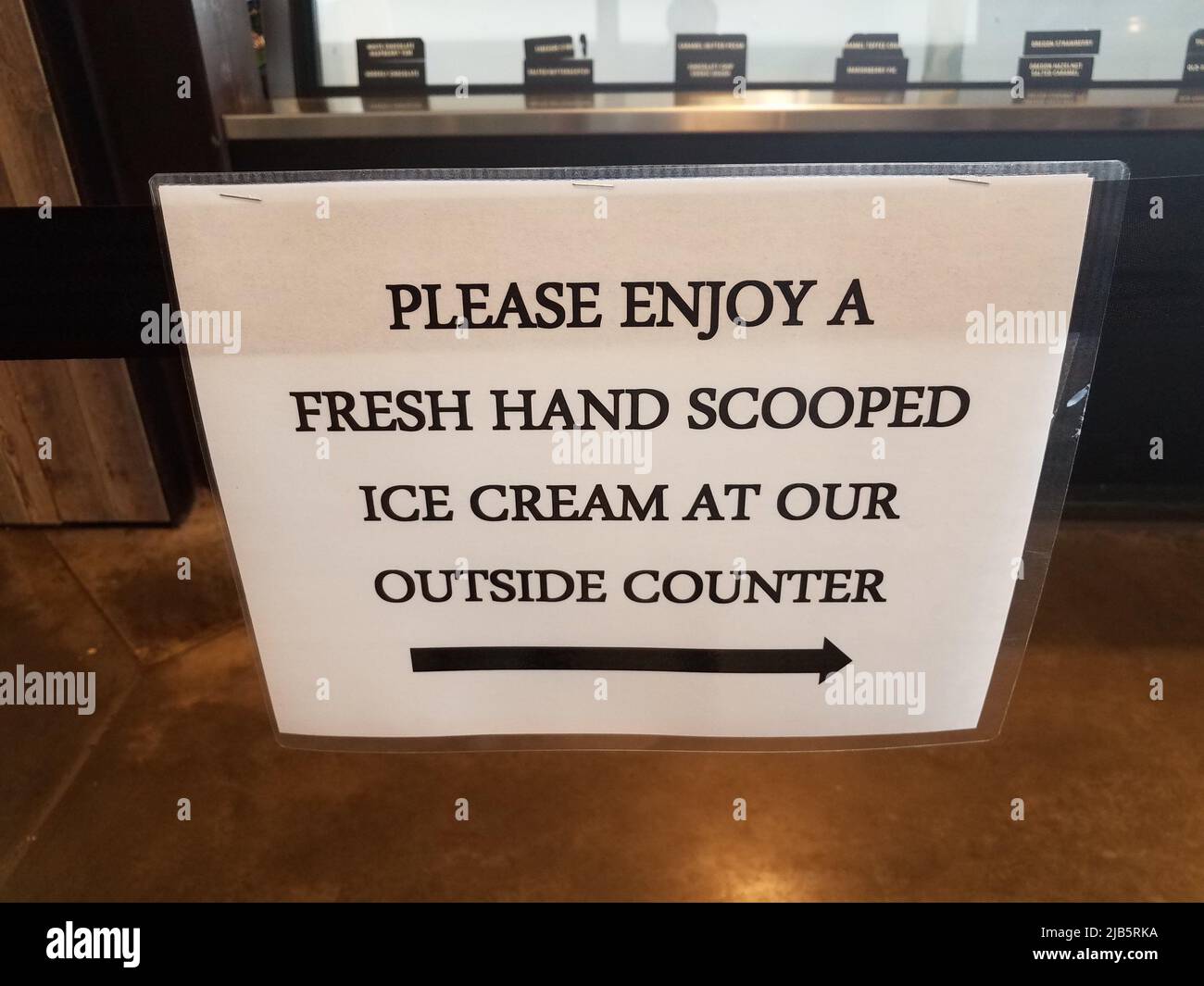 white laminated please enjoy a fresh hand scooped ice cream at our outside counter sign Stock
