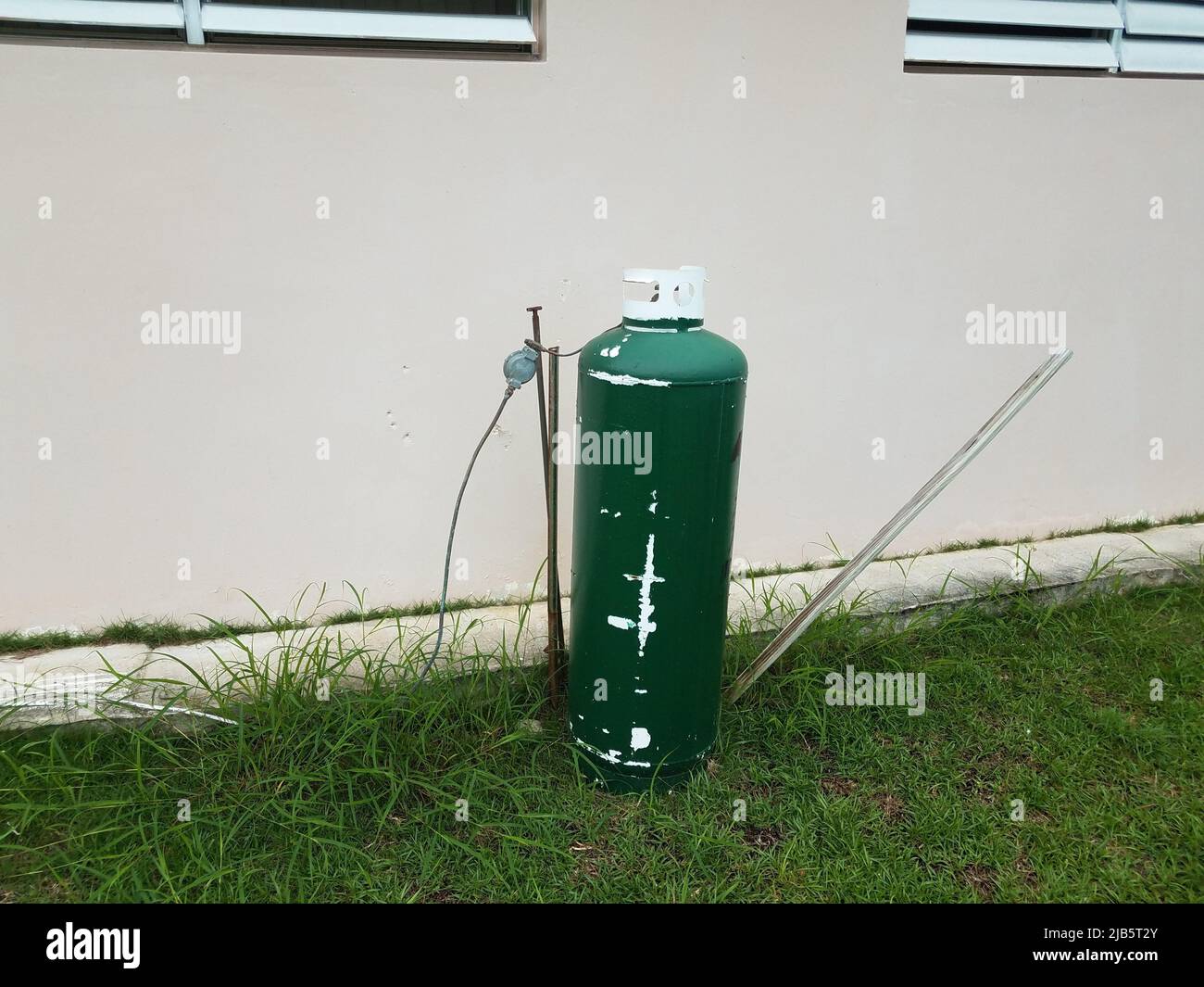 green metal gas tank and grass or lawn with house in Puerto Rico Stock
